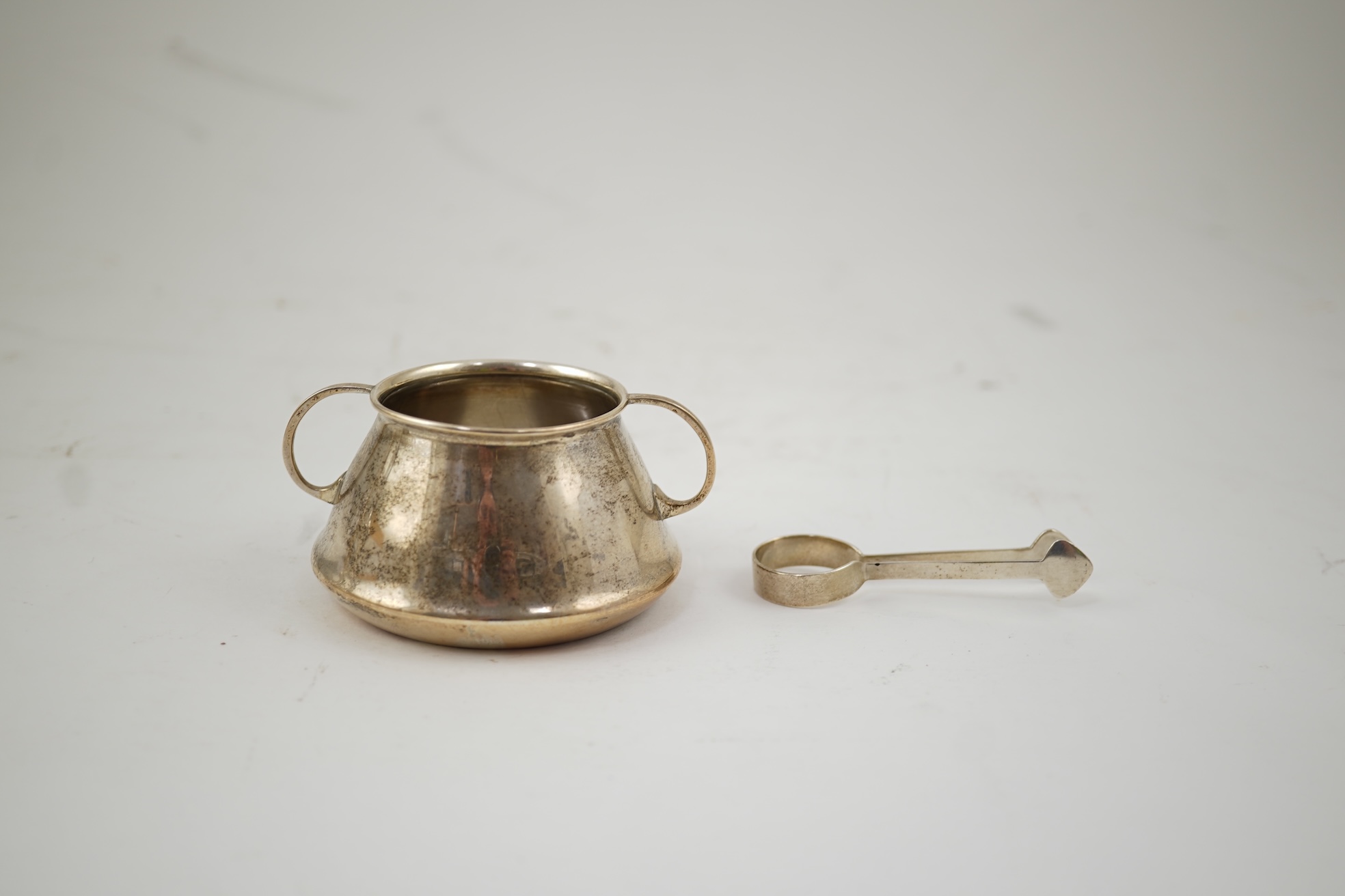 An Edwardian silver bachelor's two handled sugar bowl and matching sugar tongs, by Liberty & Co